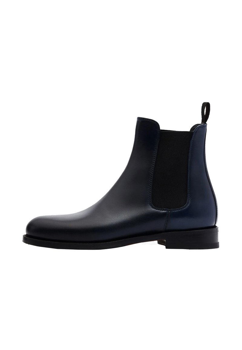 Botas Chelsea de cuero marino con paneles elásticos en los laterales, punta redonda y una pestaña en la parte trasera. Suela plana con un acabado limpio.