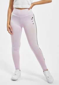 Világos rózsaszín leggings magas derékkal, oldalsó fekete csíkokkal és kis grafikai részletekkel elöl. Rugalmas anyagból készült.