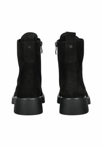 Par de botines de ante negro con cremalleras laterales, tiradores en bucle y tacones gruesos, mostrados desde atrás sobre un fondo blanco.