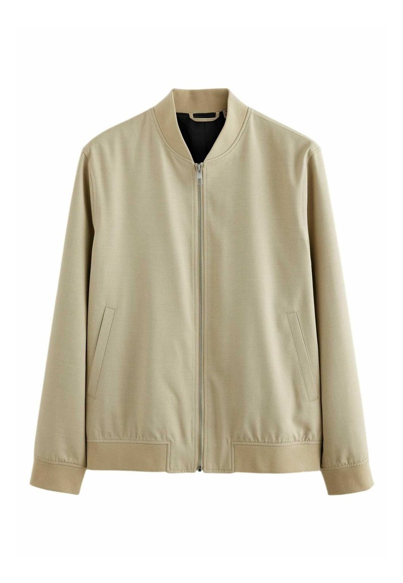 Blouson bomber beige avec fermeture éclair frontale, deux poches latérales, poignets côtelés et ourlet côtelé sur fond blanc.