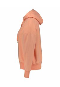 Sudadera melocotón hecha de un tejido suave, con un bolsillo canguro, capucha con cordón y puños y dobladillo acanalados. La vista lateral resalta su corte relajado.
