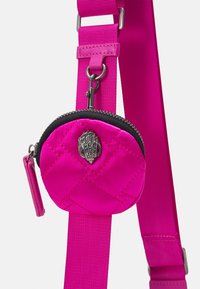 Różowa torba pikowana w okrągły wzór, z metalowym zapięciem w kolorze srebrnym i czarnym suwakiem. W komplecie z jasnoróżowym regulowanym paskiem.
