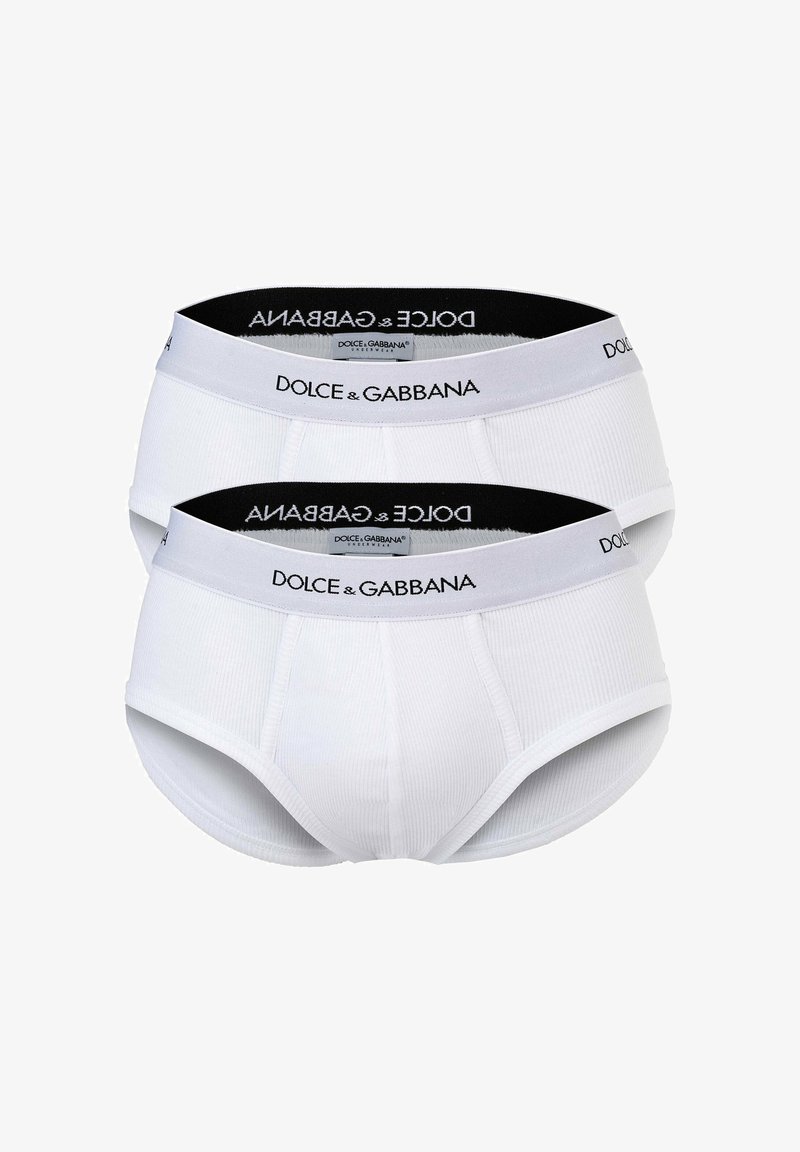 Culottes en coton blanc avec une texture côtelée, dotées d'une taille noire imprimée "DOLCE & GABBANA". Deux paires exposées.