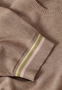 Pull en tricot marron avec un col côtelé et des poignets de manches ornés de rayures jaunes, roses et blanches. Texture douce et coupe décontractée.