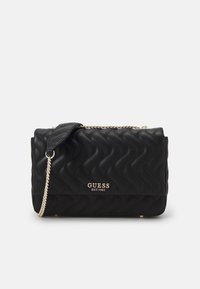 Bolso de mano acolchado negro con herrajes dorados, cadena como asa y detalle de logo. Material texturizado con forma rectangular.