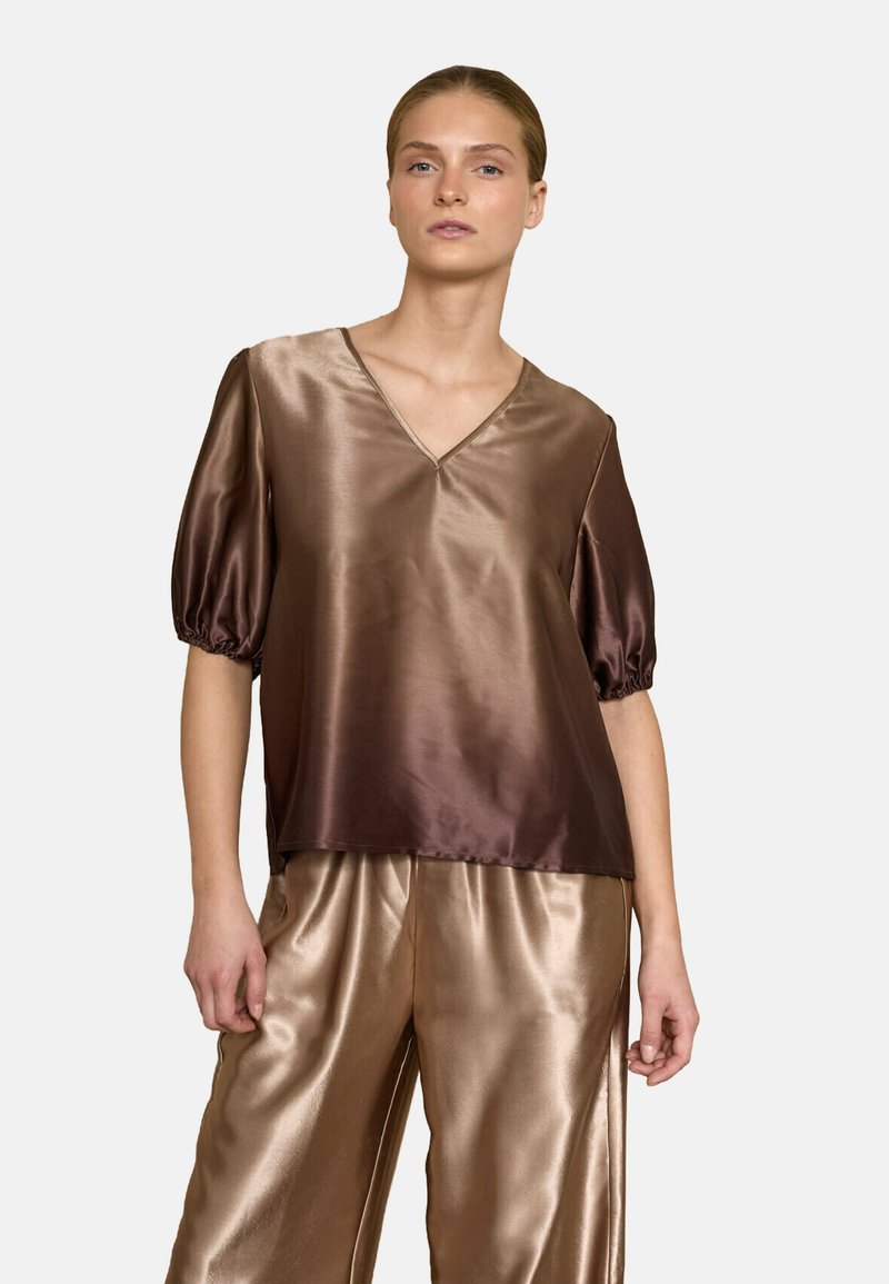 Brun satin top med V-halsudskæring og puffærmer, der har en glat tekstur. Sammen med matchende skinnende, vidde satinbukser.