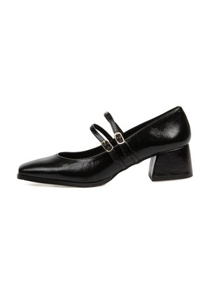 Zapatos de tacón de charol negro con punta afilada, dos correas ajustables y un tacón cuadrado grueso. Textura suave y detalles de hardware mínimos.