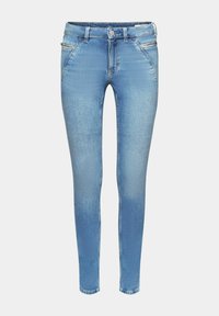 Jean denim bleu clair coupe slim avec poches à fermeture éclair et surpiqûres moutarde, fermeture avant par boutons et passants de ceinture.