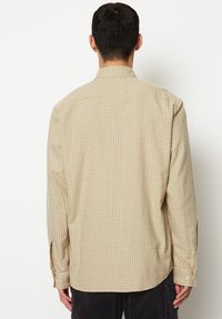 Beige Langarmhemd mit kariertem Muster. Mit Knopfmanschetten und klassischem Kragen. Lockere Passform mit Rückenpasse.
