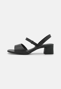 Black leather sandals with a wide front strap and an adjustable ankle strap. Features a short block heel for stability. Simple and sleek design.
