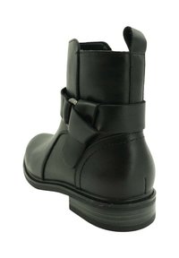 Botín de cuero negro hasta el tobillo con punta redonda, tacón bajo y un lazo decorativo en la parte posterior, con detalles de costura y una textura suave.