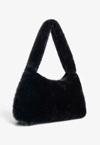 Fekete műszőrme táska ívelt formával és vastag fogantyúval. A felülete puha és bolyhos, összevarratlan kialakítású, fém alkatrészek nélkül.