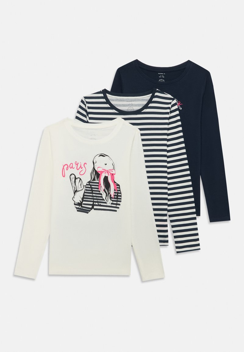 Három hosszú ujjú póló: egy fehér grafikai nyomattal, egy csíkos tengerészkék, és egy kerek nyakú csíkos tengerészkék és fehér.