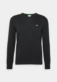 Pull col en V gris foncé en tissu doux avec manches longues et poignets côtelés ; présente un petit logo vert brodé sur la poitrine.