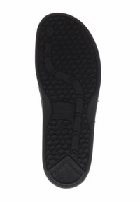 Schwarze Schuhsohle mit strukturierten Oberflächen, die Zickzack- und Kreis-Muster aufweist. Abgerundete Kanten und ein flaches Fersen-Design.