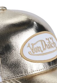 Glänzender metallischer Golddeckel mit weißem und goldfarbenem Von Dutch-Oval-Logo-Patch, das auf dem vorderen Panel gestickt ist.