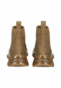 Botines de punto marrones con acentos metálicos y parte superior de malla texturizada. Presentan elasticidad en los laterales y suela de goma sólida y brillante.