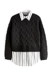 Schwarzer Kabelstrickpullover mit geripptem Saum, über einem weiß- und schwarzgestreiften Kragenhemd getragen. Weiche Textur mit auffälligen Mustern.
