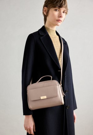 Light pink textured leather handbag with a front flap, top handle, and detachable strap, accented with a gold-tone hardware plate.