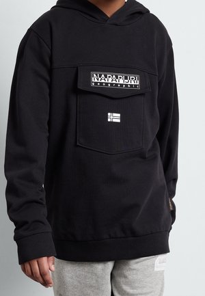 Zwarte capuchontrui met een grote borstzak, voorzien van een wit logo en accenten. Geribbelde manchetten en zoom, zachte textuur. Draagt over een grijze broek.