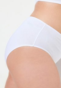 Mutanda di cotone bianco a vita alta con texture liscia e vita elastica, caratterizzata da un design senza cuciture e tessuto morbido per il comfort.