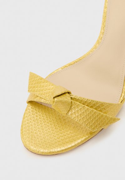 Κίτρινο υφασμάτινο σανδάλι ανοιχτού δαχτύλου με διακοσμητικό κόμπο στον μπροστινό ιμάντα, με λείο μπεζ εσωτερικό πάτο.