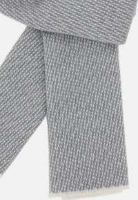 Vævet tørklæde med et blåt og hvidt houndstooth mønster, med frynset kanter og en tekstureret overflade, lavet af et blødt, varmt materiale.