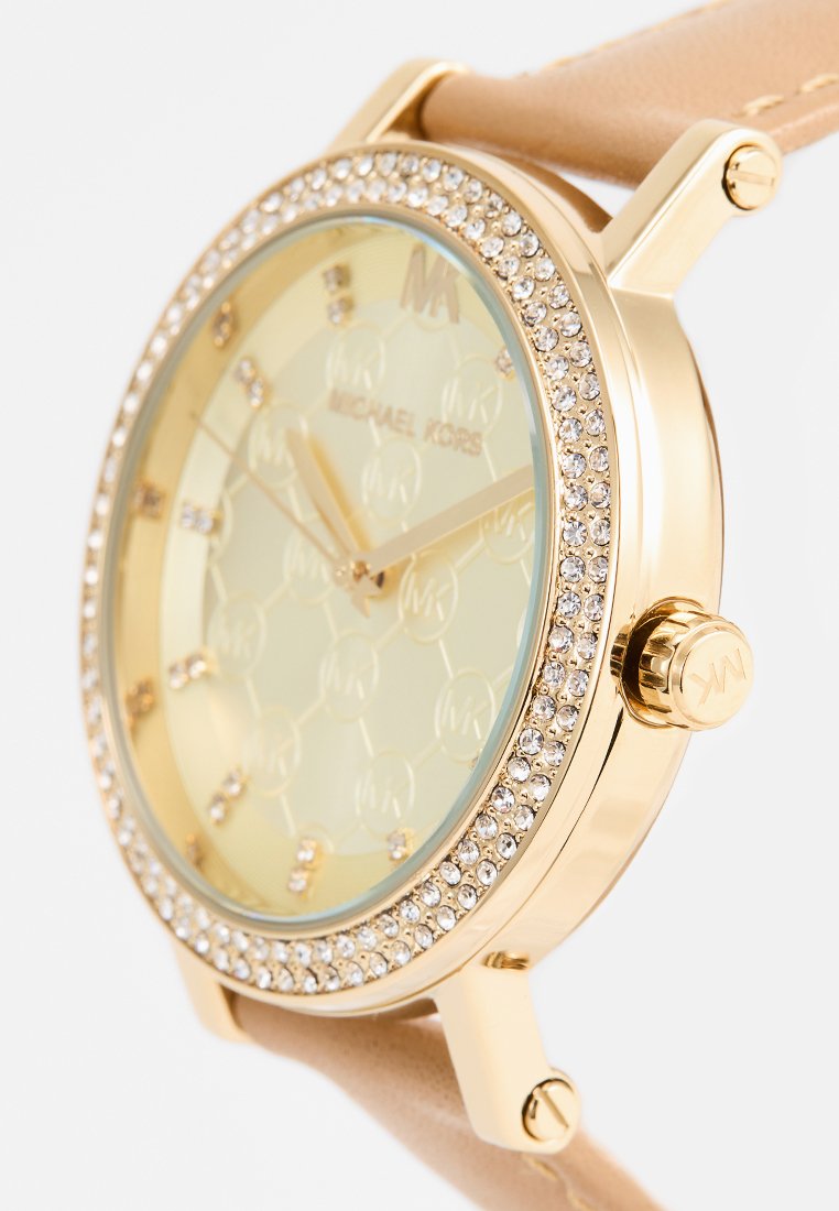 Reloj dorado con caja redonda, esfera de color amarillo claro, acentos de cristal y correa de cuero beige. Presenta un patrón hexagonal texturizado.