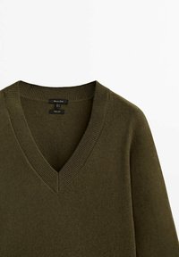 Olijfgroen V-hals trui gemaakt van zachte stof, met een geribbelde kraag en nette naden voor een gestroomlijnde uitstraling.