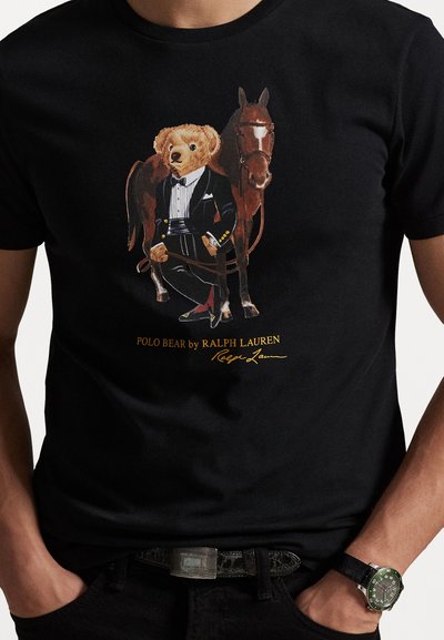 Čierne bavlnené tričko s grafikou medveďa v smokingu a koňa. Text nižšie znie "POLO BEAR od RALPH LAUREN."