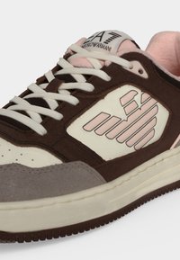 Κοντινό πλάνο καφέ, κρεμ, γκρι και ροζ sneaker με λευκά κορδόνια και λογότυπο Emporio Armani στο πλάι και στη γλώσσα.