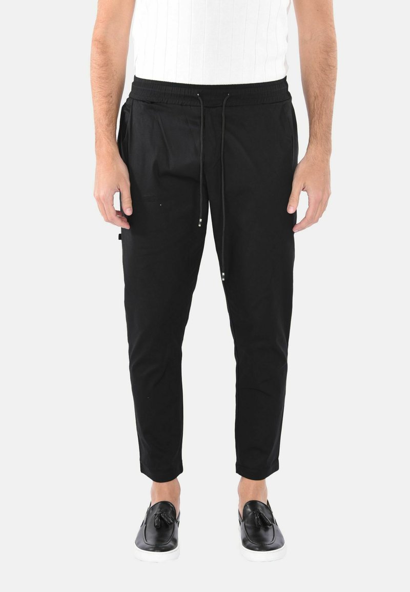 Pantaloni jogger neri aderenti con vita elasticizzata, chiusura con coulisse e tasche laterali. Tessuto liscio con una vestibilità confortevole.