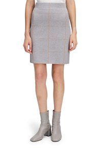 Jupe crayon en maille grise avec un motif en grille beige, dotée d'une taille haute et d'une silhouette ajustée ; associée à des bottines grises.