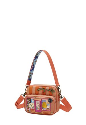 Borsa a tracolla rettangolare color corallo con tasca frontale raffigurante una vetrina di negozio di viaggi colorata e ricamo floreale sulla parte superiore.