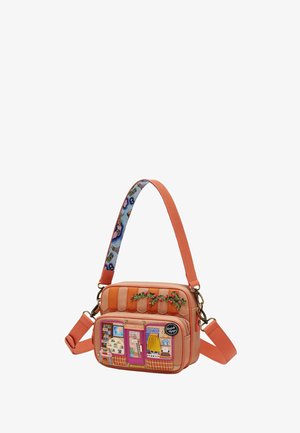 Bolso rectangular coral con bolsillo frontal que muestra una tienda de viajes colorida y bordado floral en la parte superior.