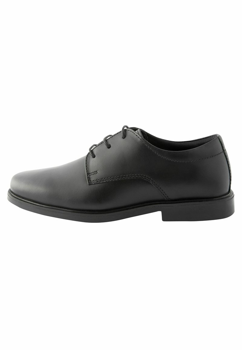 Chaussure de ville en cuir noir avec un bout rond, un avant lisse, six œillets et une semelle en caoutchouc à profil bas. Texture lisse avec des détails de couture discrets.