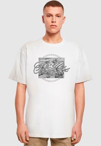 Hvid bomulds T-shirt med grafisk print, der har "Fearless Legend" og stjerne accentuer, korte ærmer og en afslappet pasform.