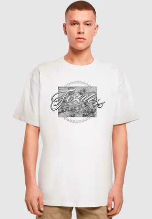 Hvid bomulds T-shirt med grafisk print, der har "Fearless Legend" og stjerne accentuer, korte ærmer og en afslappet pasform.