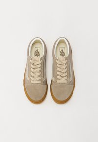 Baskets en daim beige avec une finition texturée, présentant des accents crème, un laçage classique et une semelle en gomme pour la traction.