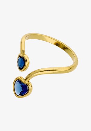 Gouden open ring met twee hartvormige blauwe edelstenen, één groter en één kleiner, aan elk uiteinde gezet.