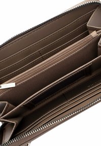 Brown faux leather wallet interior with multiple card slots, a zippered pocket, and stitching details; features a silver zipper.