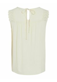 Blusa color crema con detalles de encaje en los hombros, cierre trasero con lazo y un corte holgado hecha de una tela ligera y texturizada.