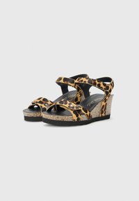Sandales compensées à imprimé léopard avec des brides entrecroisées, un talon en wedge textur�é et des accents de boucle noire. Semelle sombre et semelle intérieure rembourrée.
