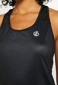 Zwarte sportieve tanktop met een subtiel textuurpatroon, dunne bandjes en een wit logo op de borst. Het materiaal lijkt glad en rekbaar.