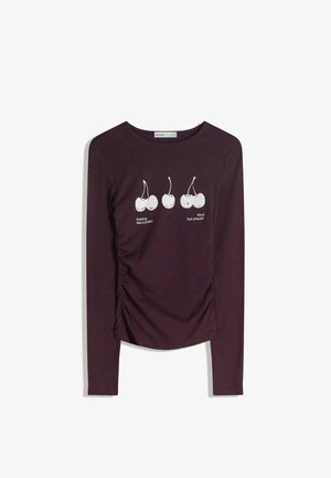 Pitkähihainen viininpunainen pusero pehmeästä kankaasta, jossa on sivuilla laskokset; valkoinen kirsikkakuva teksteillä "Feeling like a poem" ja "Kind but chaotic".