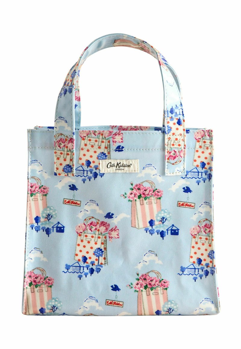 Bolsa de tela azul con patrones florales y de lunares, cuenta con asas cortas y una etiqueta con el logo. Diseño ligero y rectangular.