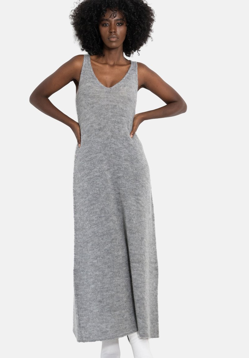 Szara dzianinowa sukienka midi z dekoltem w serek, bez rękawów, o luźnym kroju, charakteryzująca się miękką fakturą i zwiewną sylwetką.