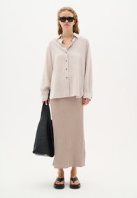 Light beige linen button-up shirt, ribbed beige midi skirt, black chunky sandals, and a black leather tote bag. Minimalist, casual design.