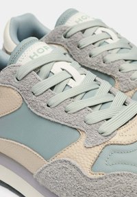 Baskets bleu clair et beige avec un mélange de matériaux en daim et en mesh, des accents texturés et des lacets ton sur ton assortis.