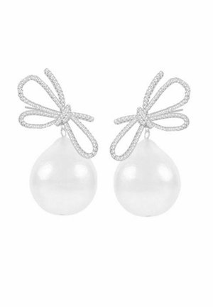 White pearl drop earrings with silver-tone bow accents encrusted with small clear crystals. Smooth surface, teardrop shape.